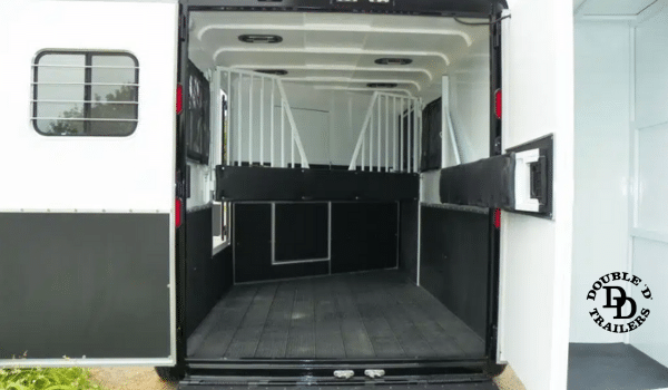 See-through tubular dividers and padded walls in a horse trailer, designed to reduce stress during transport.