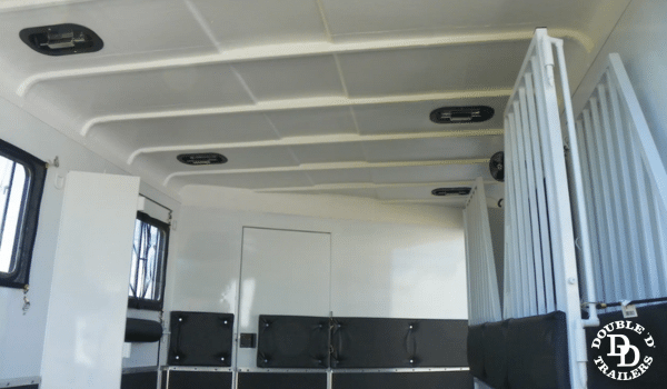 Fully insulated walls and ceiling in a horse trailer to control temperature and reduce noise for comfort.